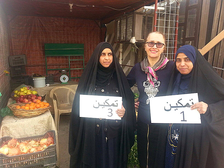 Hala Sarraf (of IHAO) stands with two displaced women who are recent recipients of small business start-up funds.