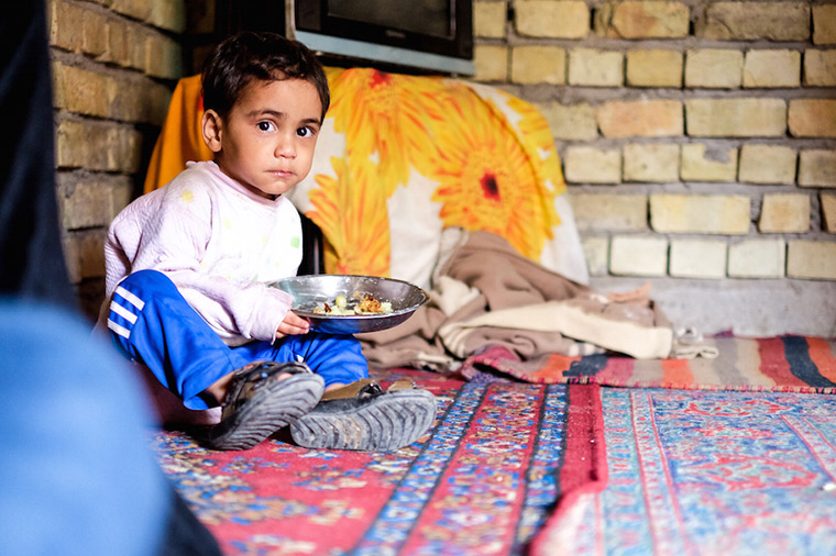 A young displaced Iraqi boy eats his lunch in a temporary home.