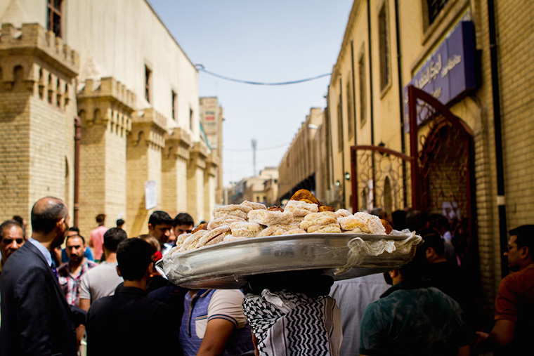 A tray of pastries is carried above the crowds in Baghdad's Mutanabi Street.
