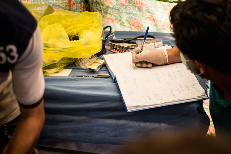 Dr. Nasir keeps a record of conditions found in displaced camp residents, as he assesses their conditions.