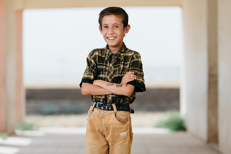 When looking at this cute boy, displaced by ISIS and standing confidently with temporary tattoos applied to one arm, it's shattering to think about the plans ISIS has for boys just like him.