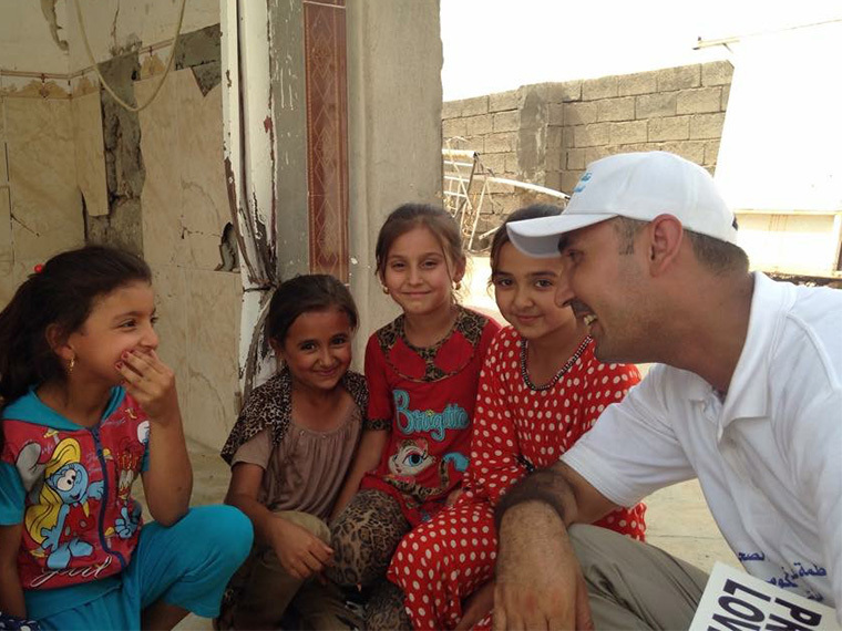 Ahmed takes time out from delivering relief aid in Iraq to talk to some giggly girls.