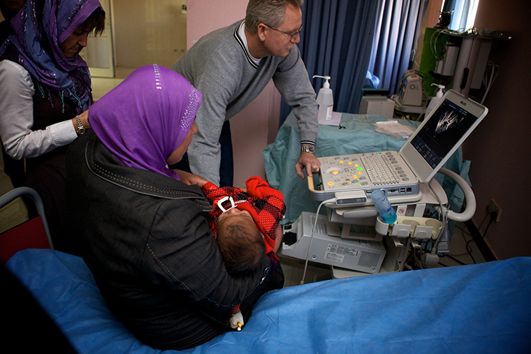Dr. Kirk examines the echocardiogram of a baby sick with a heart defect in Fallujah, Iraq.