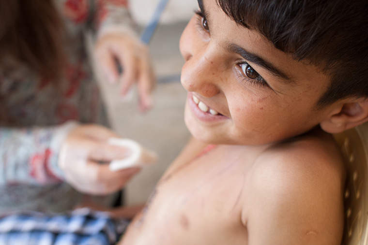 Mohammad smiles while his bandages are changed, following lifesaving heart surgery via Preemptive Love Coalition