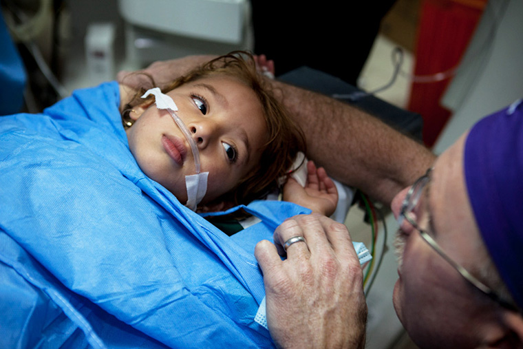 A young patient looks into the eyes of her doctor.